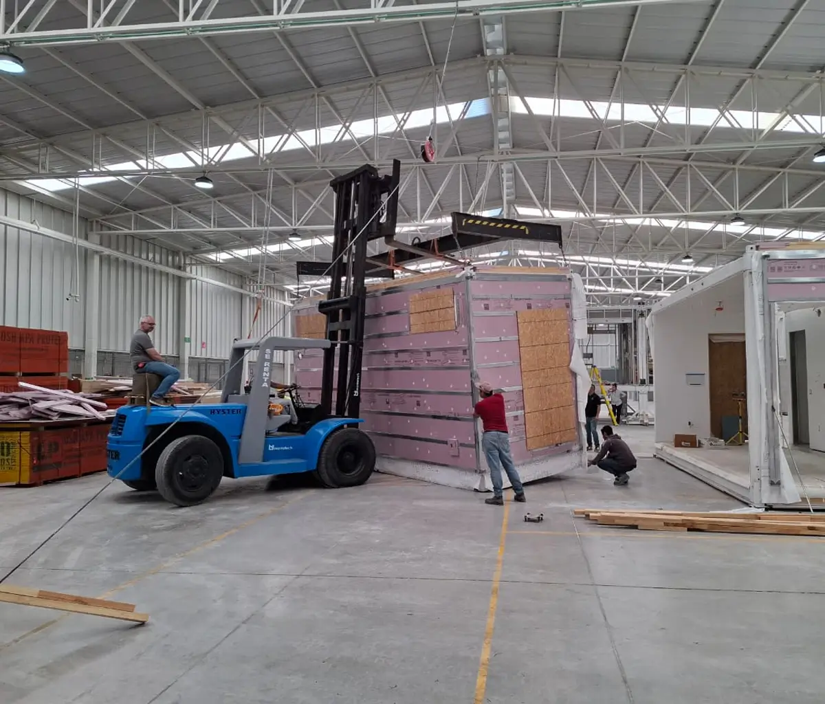 An Olympus module lifted across the factory floor during quality checks
